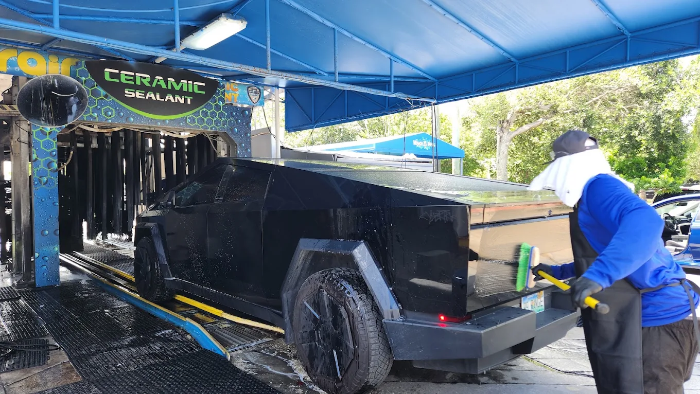 Palm Beach Auto Spa team hand-washing a vehicle under the ceramic sealant arch