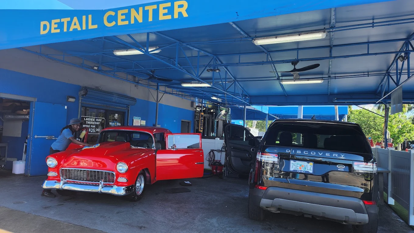A classic car and an SUV being detailed at the Palm Beach Auto Spa detail center